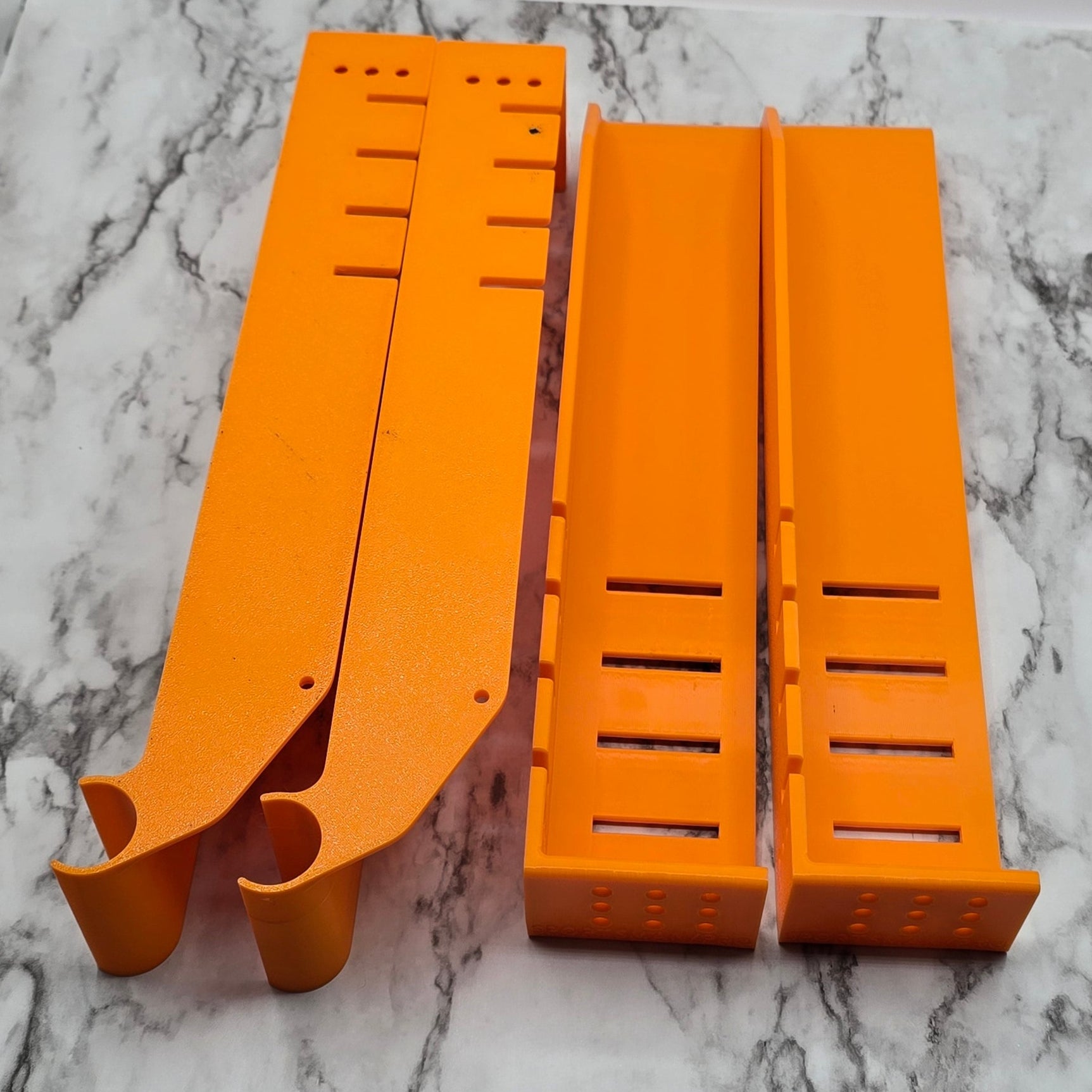 Two orange plastic strips on a marble countertop