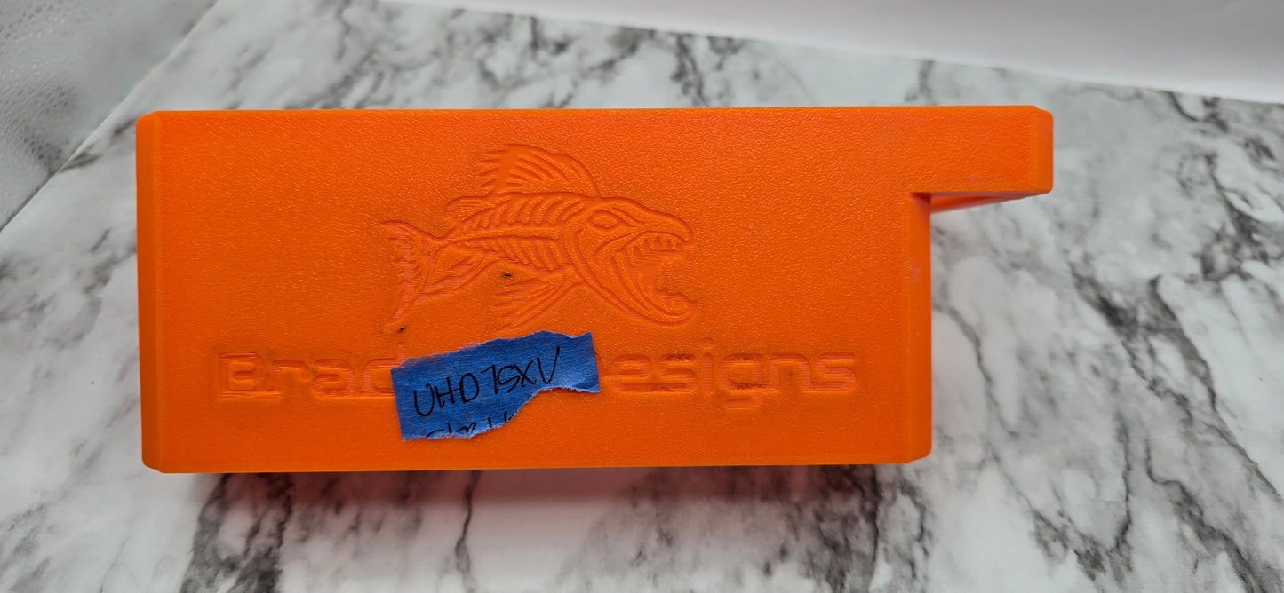 Orange tool with a fish design and 'Bradget Designs' branding on a marble surface