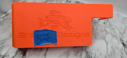 Orange tool with fish design and 'Bradget Designs' branding on a marble surface