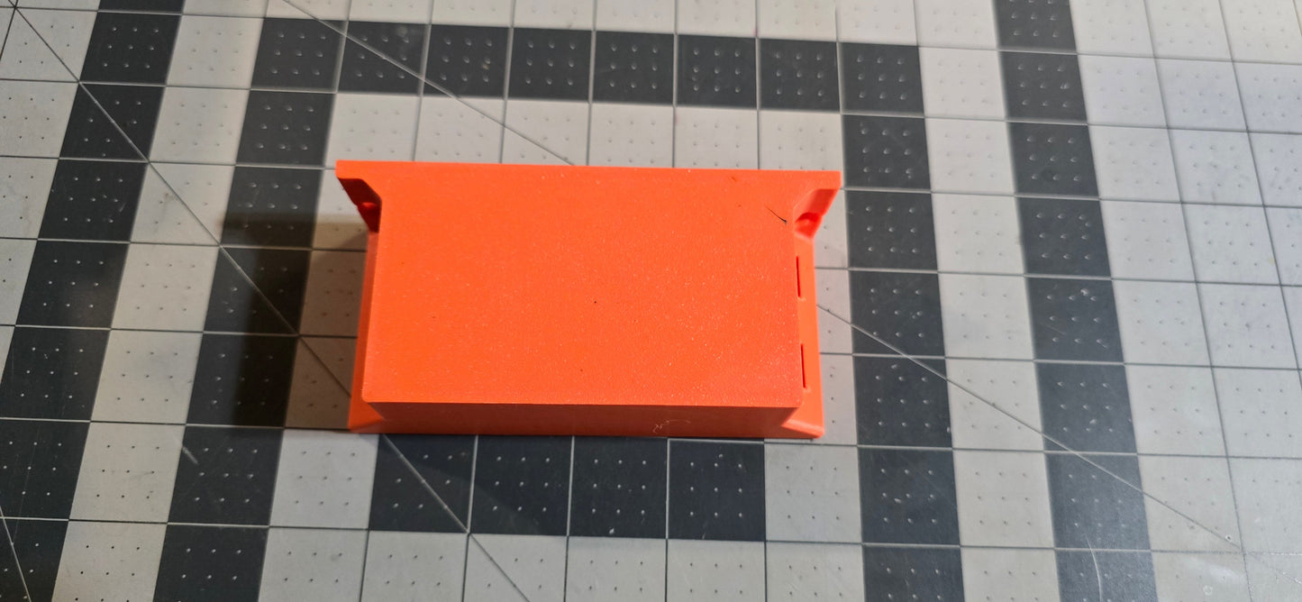 Orange rectangular object on a grid-patterned surface