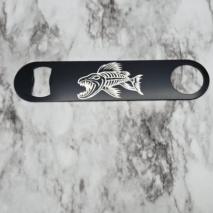 Black bottle opener with a fish design on a marble surface