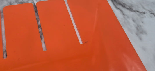 Orange plastic tray with cut-out handles on a marble surface